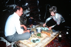 Mansour's uncle David enjoys a meal on an antique rug of his own